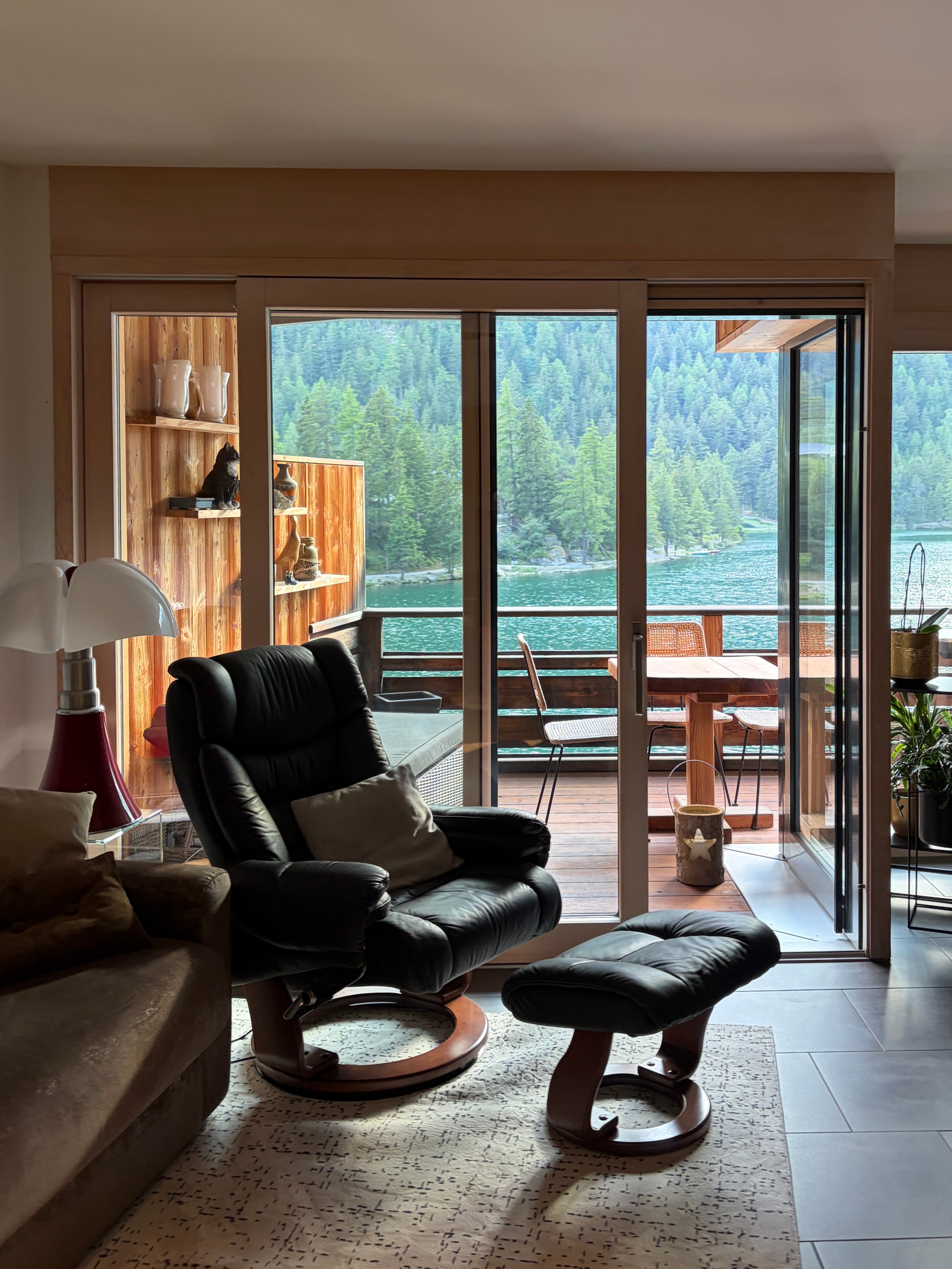 The living room at The Alpine Nest, opening onto the private balcony with direct lake and mountain views